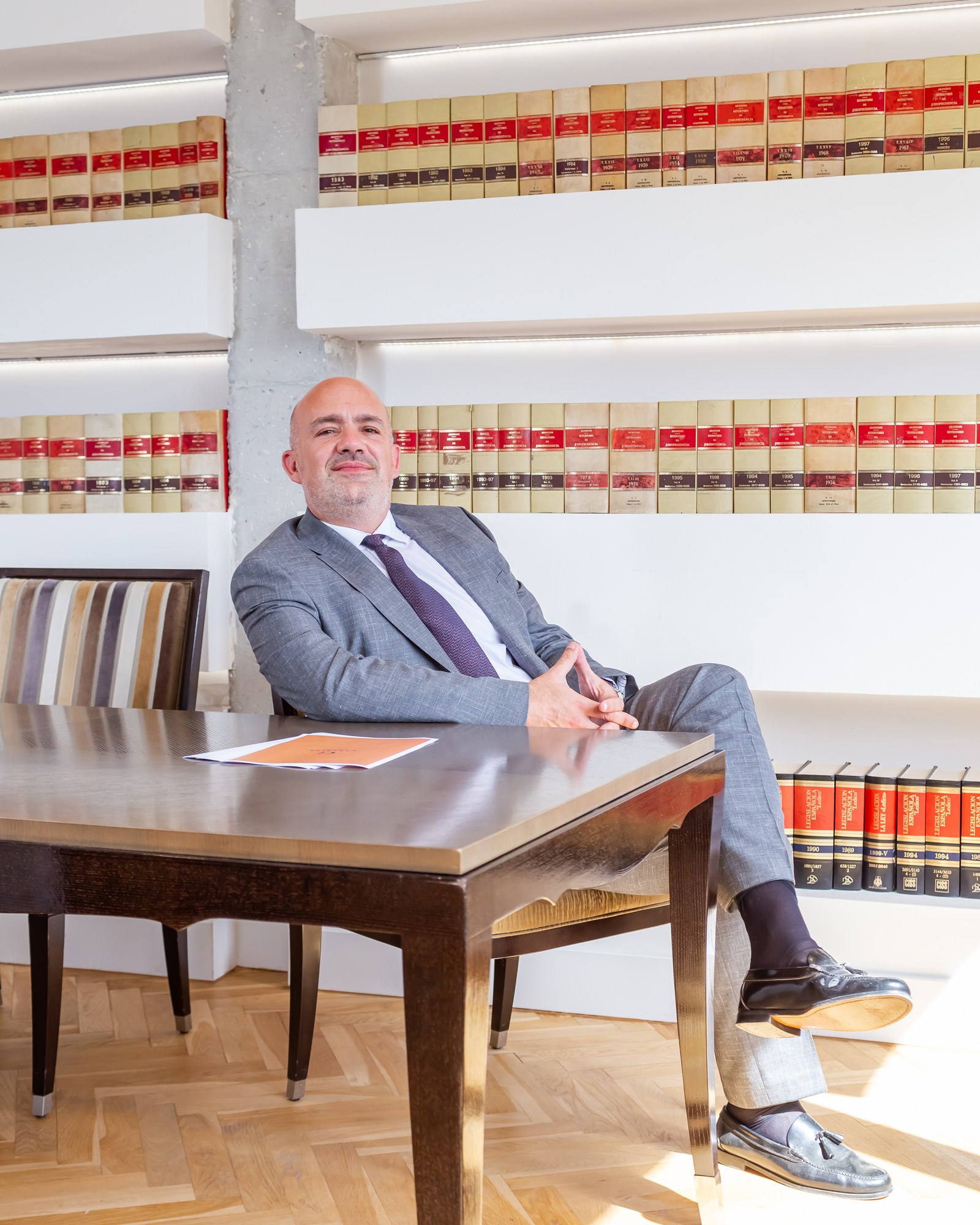 Antonio José García Linares, seated at the office table with a single document before him, leaning back in his chair and looking out of frame.