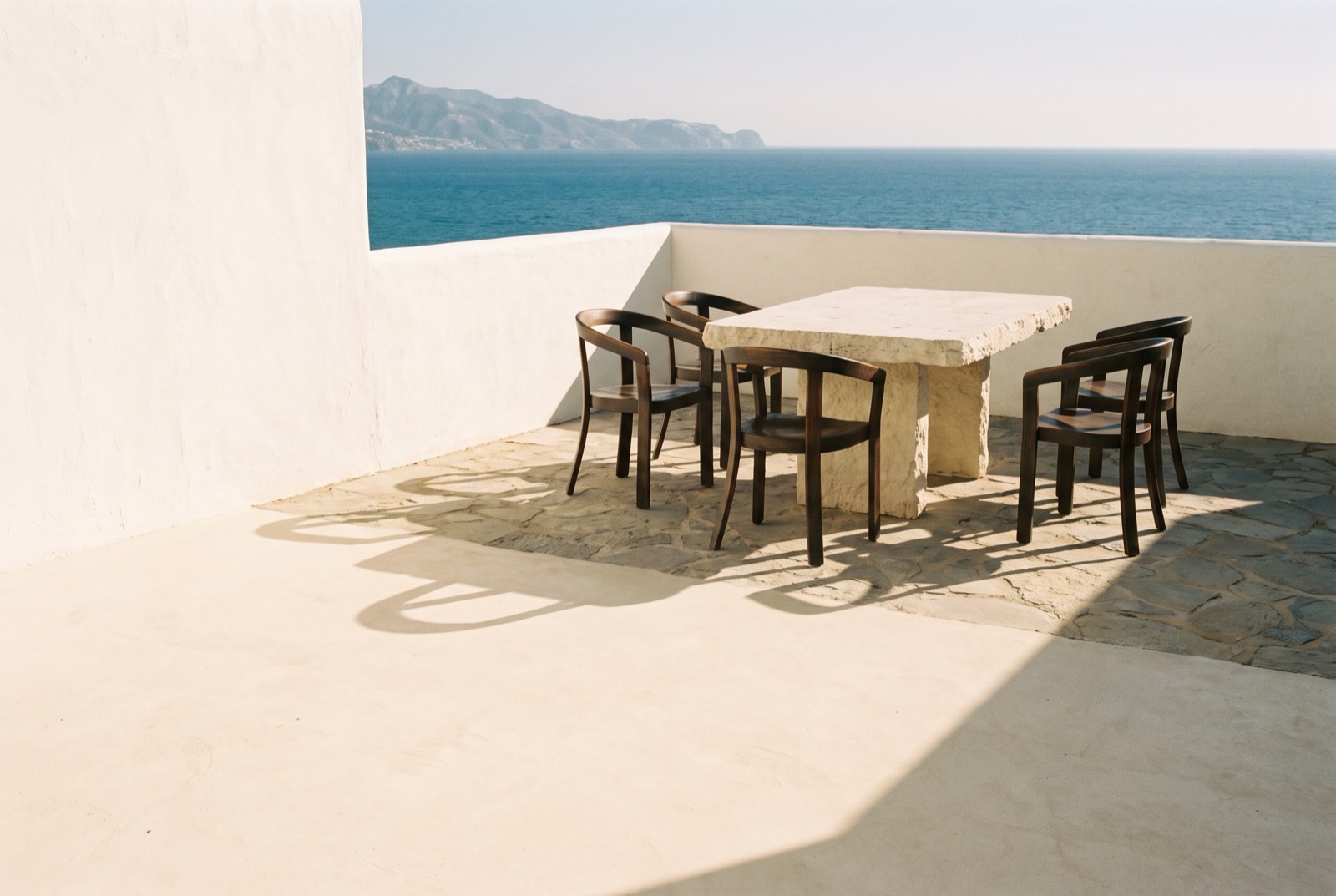 Four chairs around the empty table, each turned at a different angle