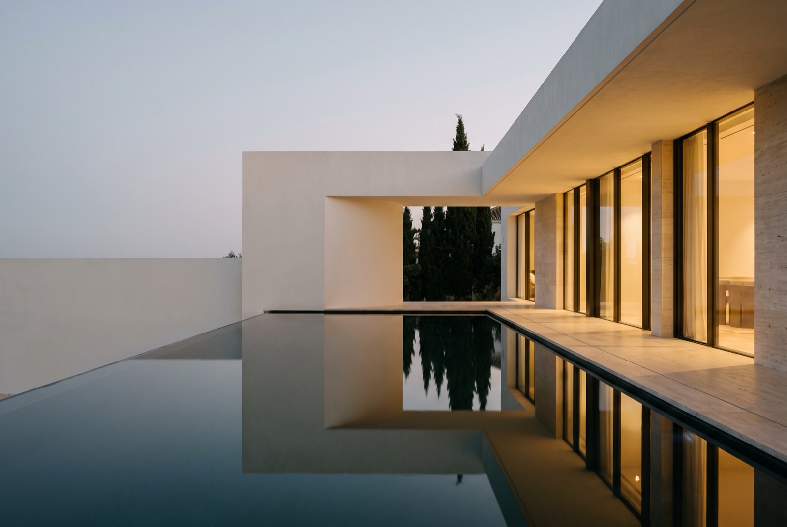 Contemporary Marbella villa reflected in its infinity pool at dusk